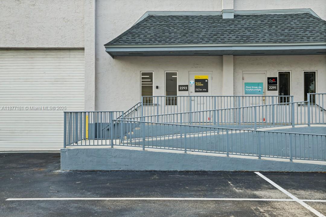 An exterior view of a commercial building with a wheelchair ramp and two entrance doors — 2273 NW 82nd Ave # 2293, Doral FL 33122, DORAL, FL