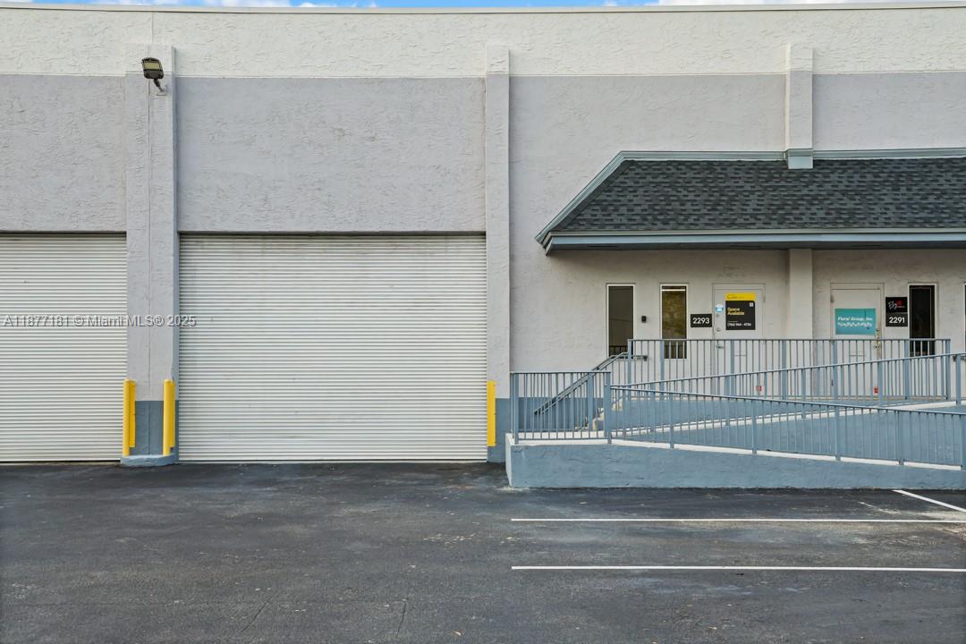 The exterior of a commercial building features a roll-up bay door and two entrance doors — 2273 NW 82nd Ave # 2293, Doral FL 33122, DORAL, FL