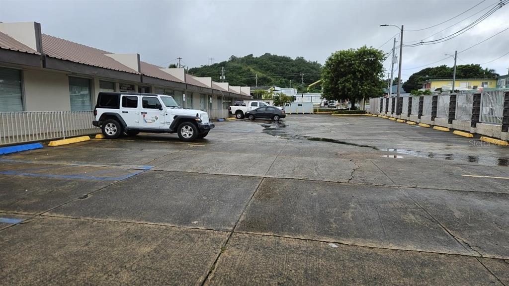 A white Jeep is parked in a paved parking lot in front of a commercial building — 2 CALLE 5, FAJARDO, PR