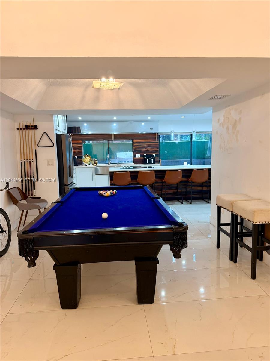 A game room features a blue pool table, tile flooring, and an open kitchen area — 8646 SW 94th St, Miami FL 33156, MIAMI, FL