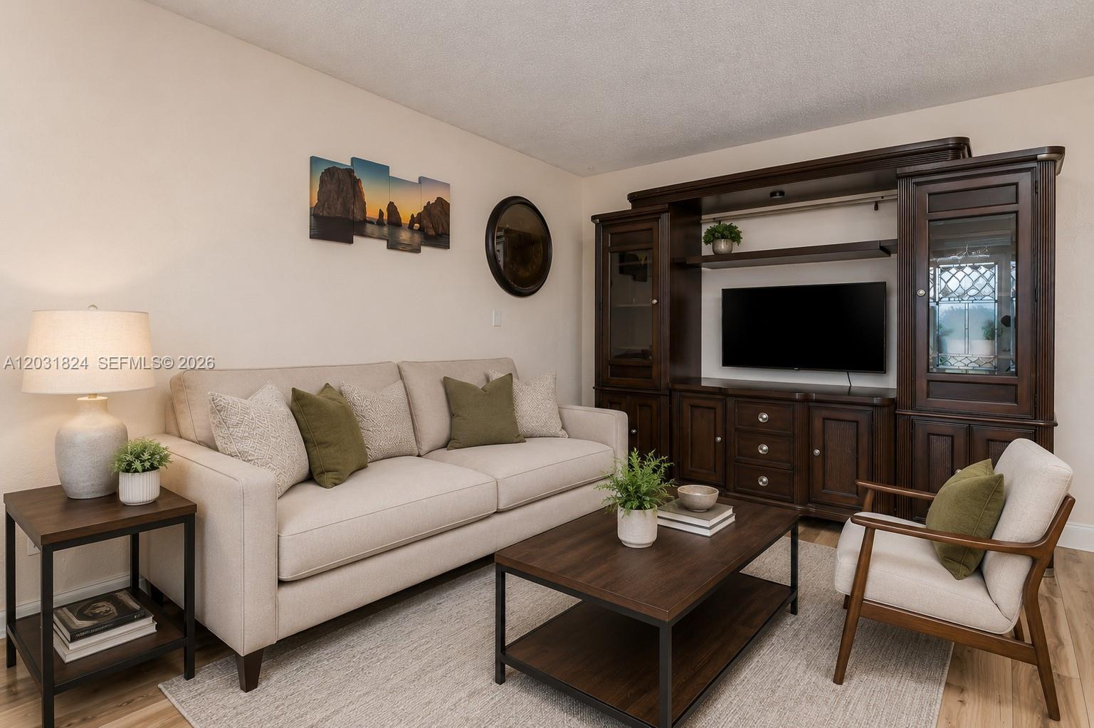 A living room features a beige sofa, wooden coffee table, armchair, and a large entertainment center — 630 NW 199th St, Miami Gardens FL 33169, MIAMI GARDENS, FL