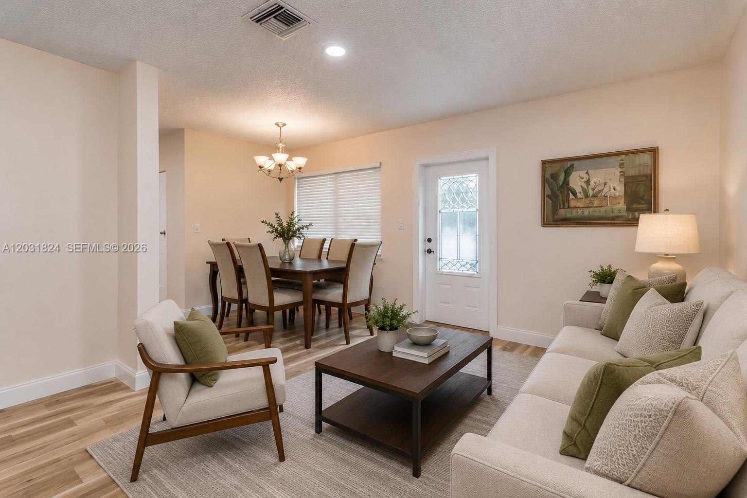 A living room and dining area feature light-colored walls, wood-look flooring, and neutral furniture — 630 NW 199th St, Miami Gardens FL 33169, MIAMI GARDENS, FL