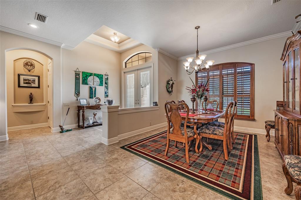 A dining room with a plaid rug, wooden furniture, and a tray ceiling — 34115 AMERICANA AVENUE, DADE CITY, FL