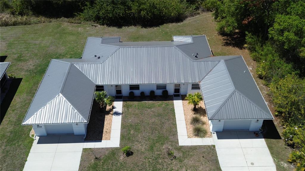 An aerial view of a duplex with a metal roof and two attached garages — 1061+1065 NOMAD ROAD, PUNTA GORDA, FL