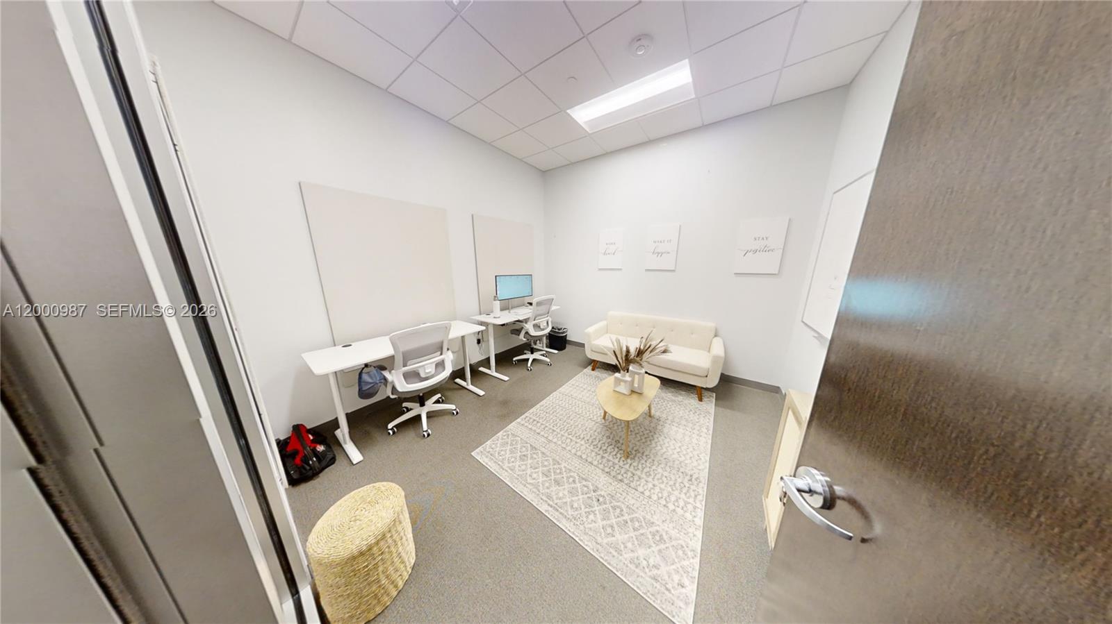 A small office features two desks, a white sofa, a coffee table, and a rug — 1501 Biscayne Blvd # D, FL 33132, FL