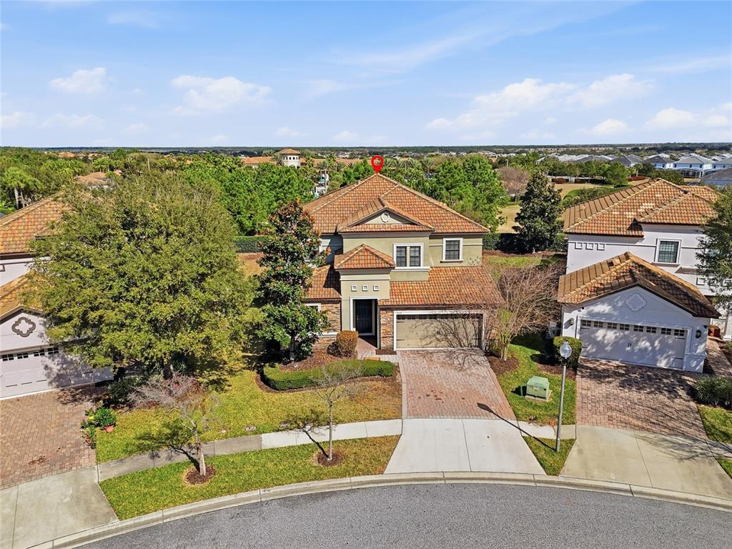 An aerial view shows a two-story suburban house with a tiled roof and brick driveway — 9039 SHADOW MOUNTAIN STREET, DAVENPORT, FL