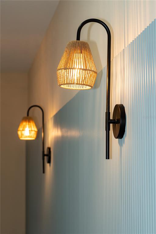 Two wall-mounted lamps with woven shades are attached to a light blue ribbed wall — 7617 AMHERST STREET, TAMPA, FL