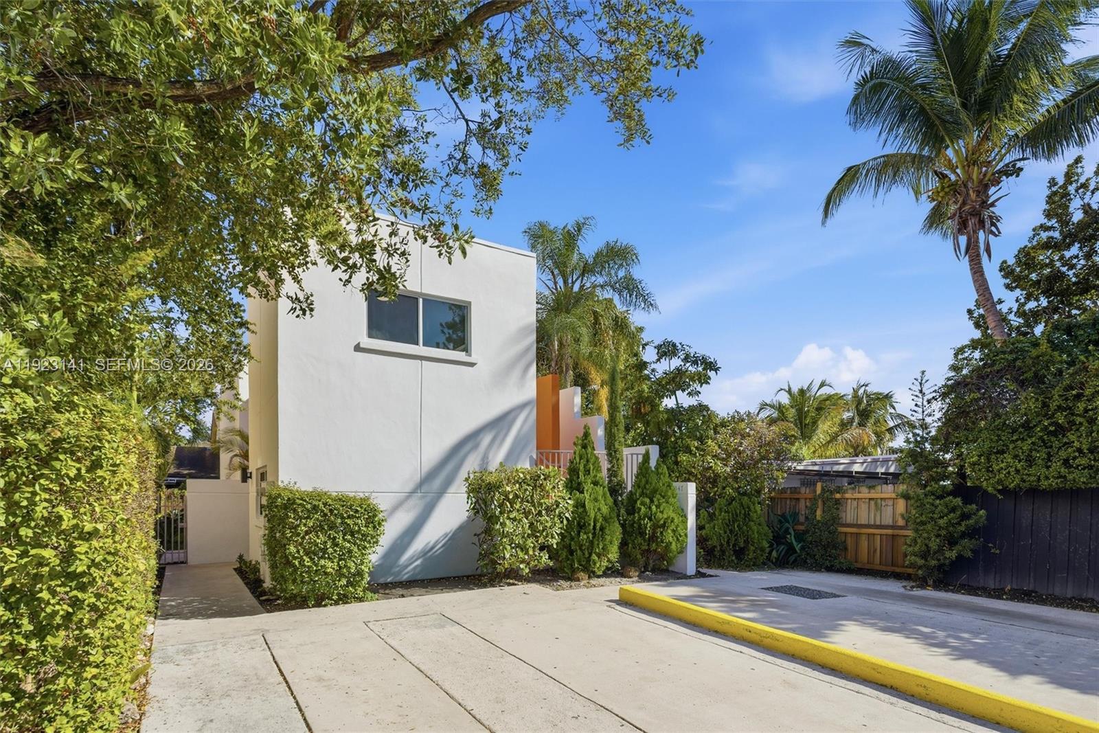 A modern white building stands next to a driveway with a yellow curb and landscaping — 1045 SW 25th Ave, Miami FL 33135, MIAMI, FL