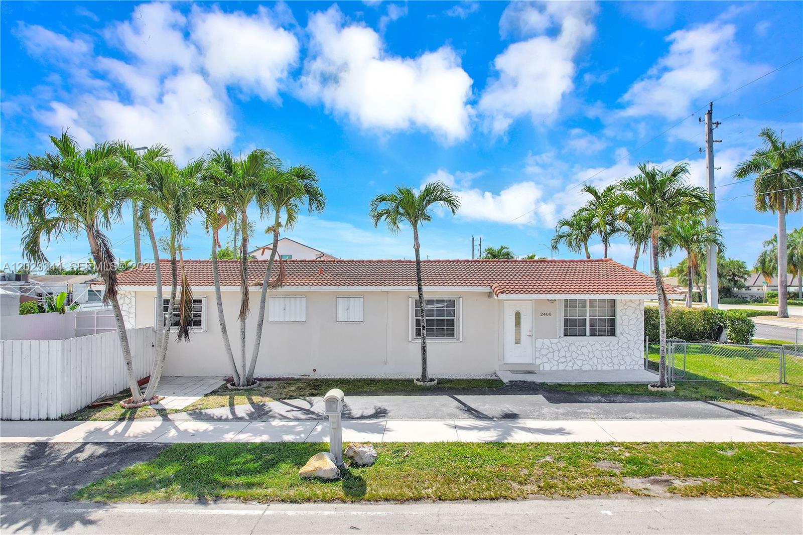 A single-story house with a tiled roof, palm trees, and a white stone facade — 2400 SW 103rd Ct, Miami FL 33165, MIAMI, FL