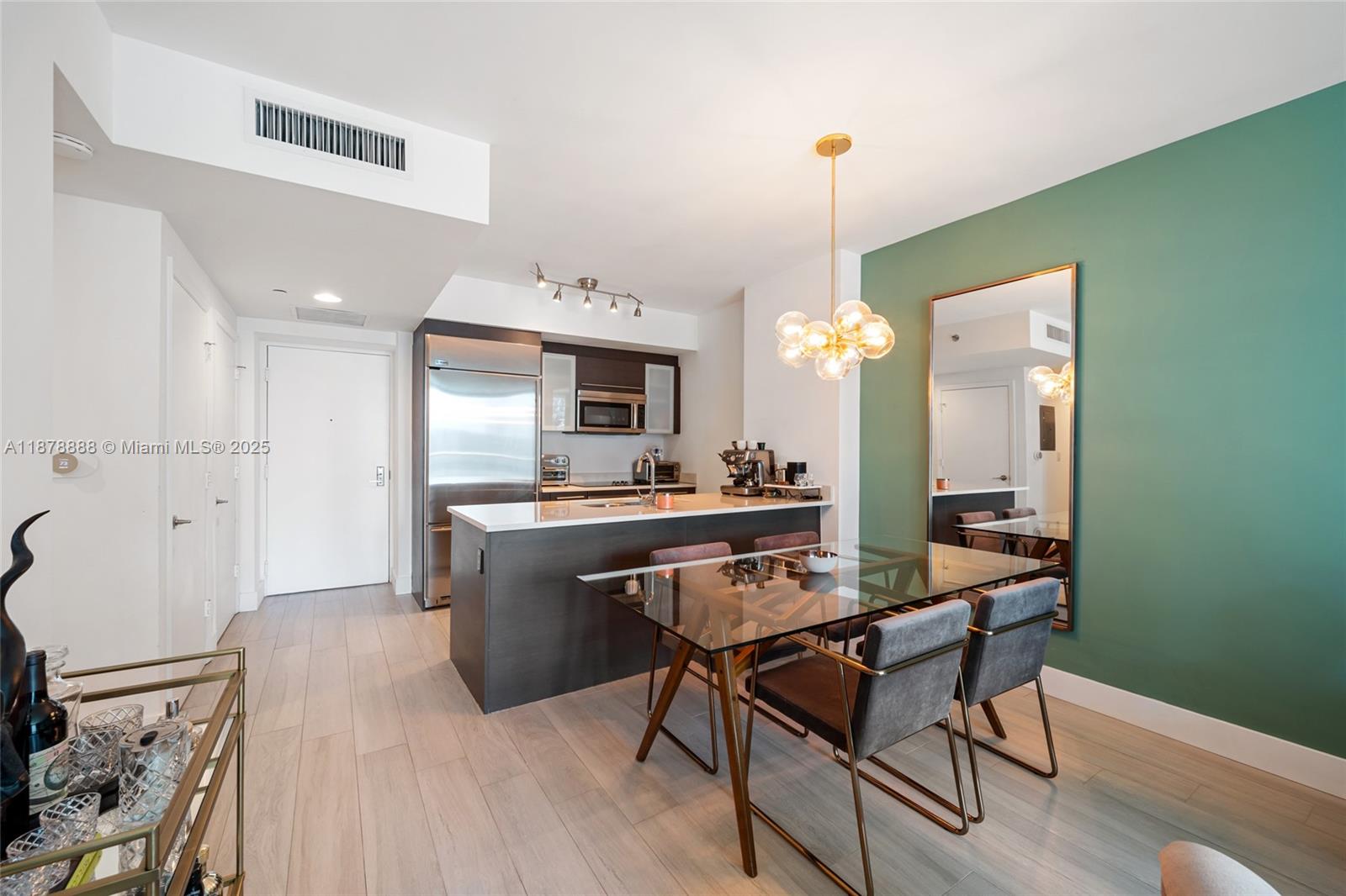 A modern living room features a grey sofa, an armchair, and floor-to-ceiling windows with city views — 55 SE 6th St # 1908, Miami FL 33131, MIAMI, FL