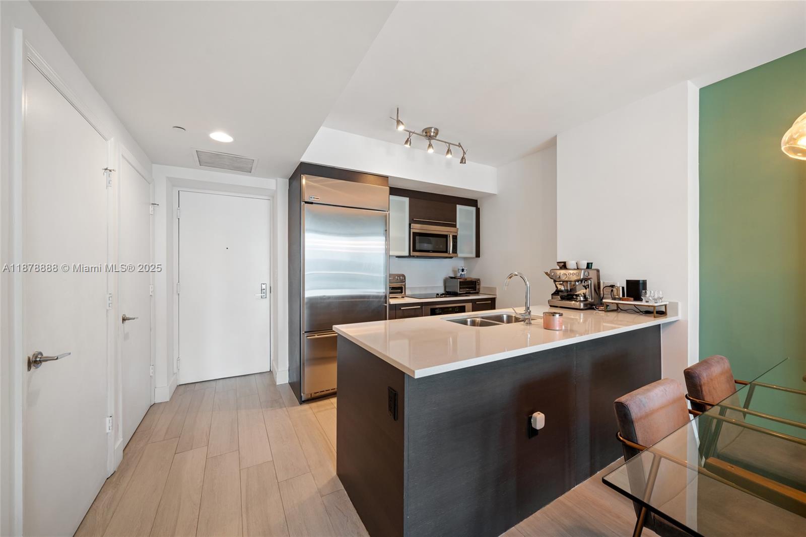 A modern living room features a sofa, pink armchair, television, desk, and floor-to-ceiling windows — 55 SE 6th St # 1908, Miami FL 33131, MIAMI, FL