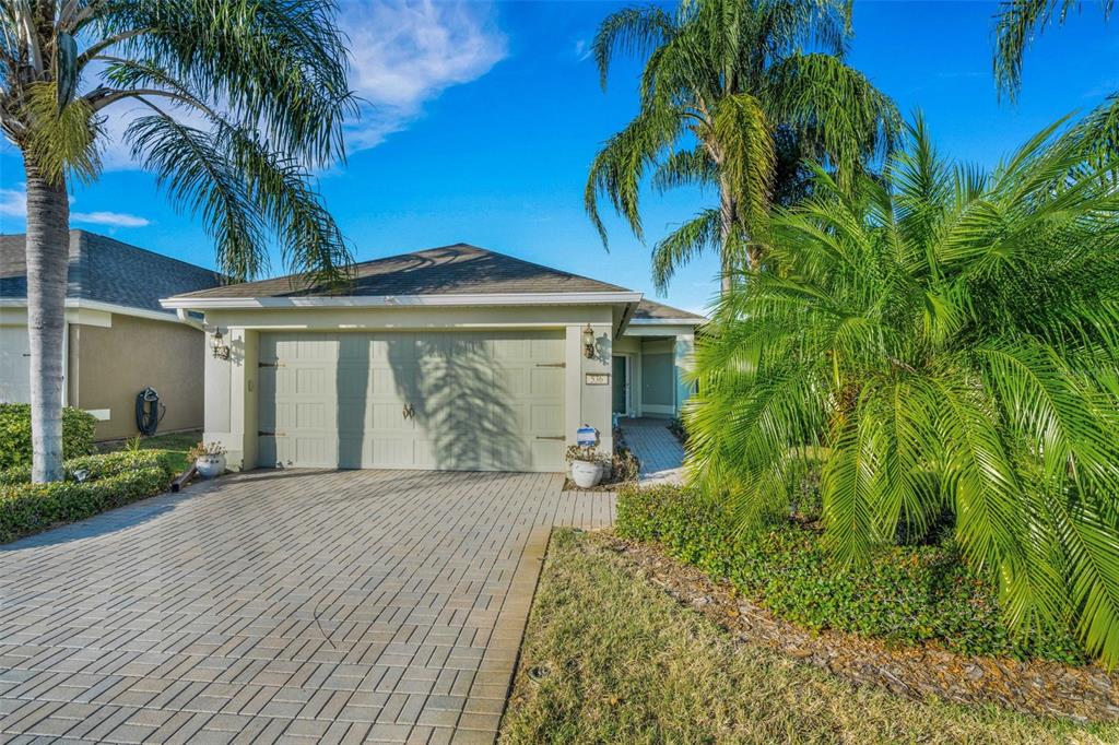 A single-story house with a paved driveway, two-car garage, and palm trees in the front — 536 ARENA DRIVE, DAVENPORT, FL