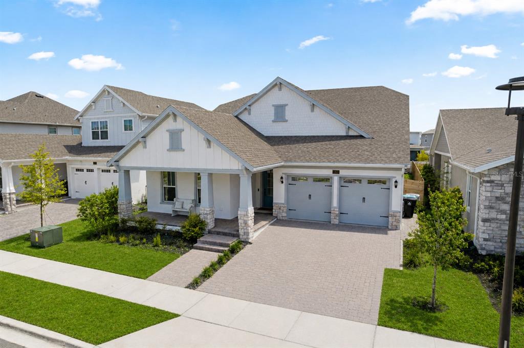 A two-story house with a white facade, stone accents, and a two-car garage — 13301 MCMILLAN DRIVE, ORLANDO, FL