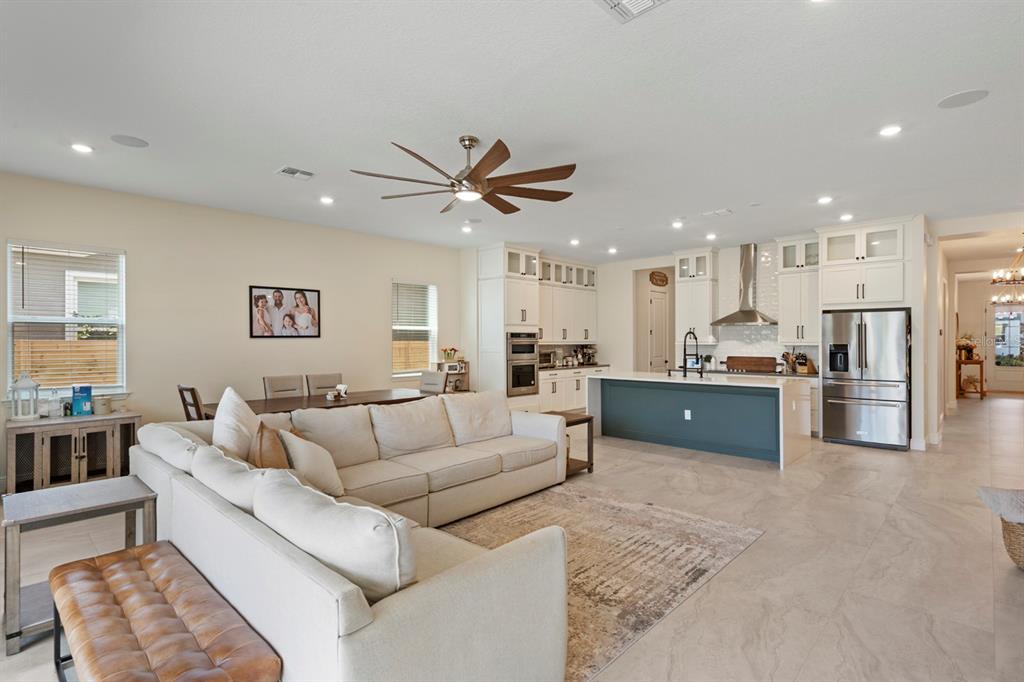 An open-concept living room and kitchen featuring a large sectional sofa and a blue island — 13301 MCMILLAN DRIVE, ORLANDO, FL