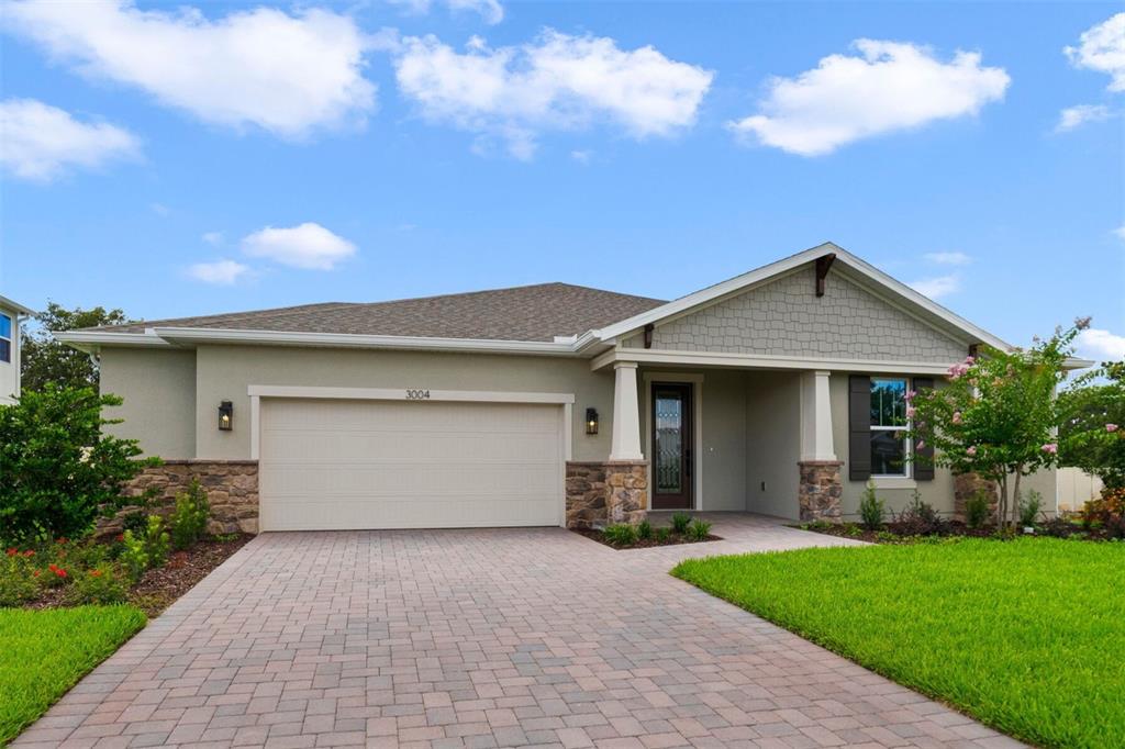 A single-story house with a stone-accented facade, a two-car garage, and a paved driveway — 3004 WATER CLOVER COURT, APOPKA, FL