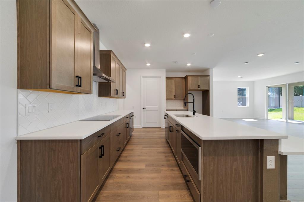 A kitchen with wood cabinets, white countertops, a center island, and light-colored flooring — 3004 WATER CLOVER COURT, APOPKA, FL