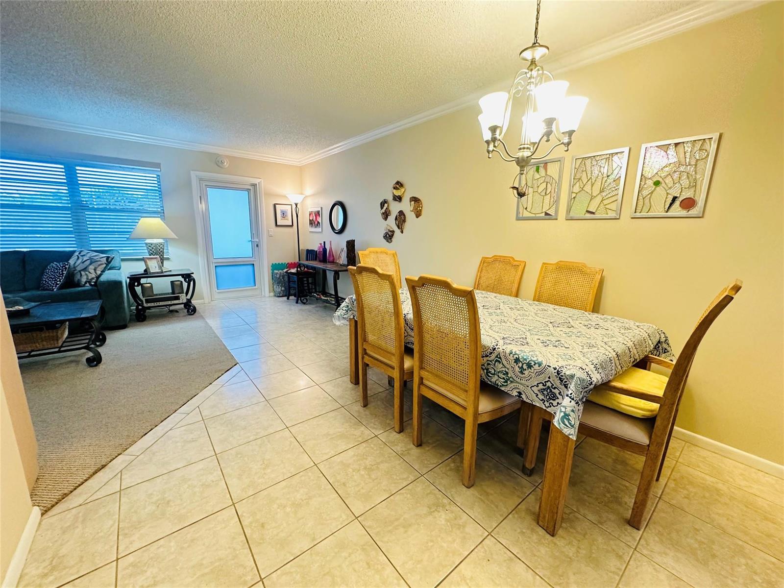A dining area with a table and chairs sits adjacent to a living room space — 2007 Islewood D # 2007, Deerfield Beach FL 33442, DEERFIELD BEACH, FL
