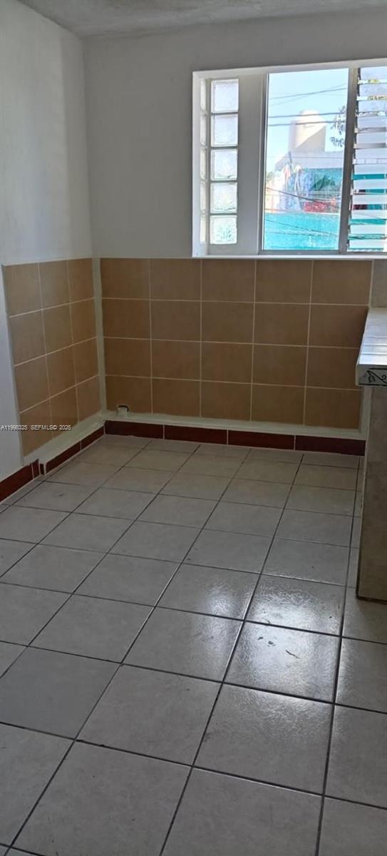 A kitchen area features light-colored floor tiles, tan wall tiles, and a window — 9 Calle 8-92 Zona 11, MA 01057, MA