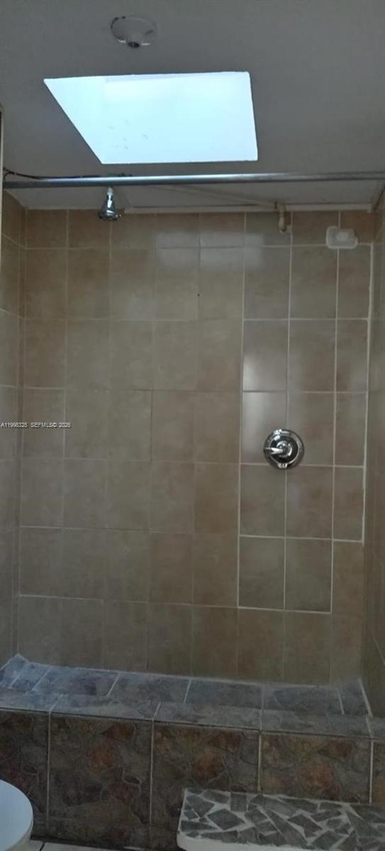 A tiled walk-in shower features a built-in bench and a skylight above — 9 Calle 8-92 Zona 11, MA 01057, MA