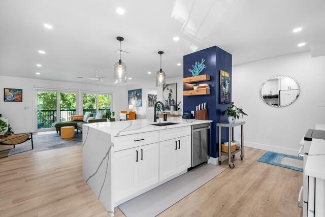 A modern kitchen features a white quartz island with a dark blue accent wall — 18460 SE Wood Haven Lane # H, Jupiter FL 33469, JUPITER, FL