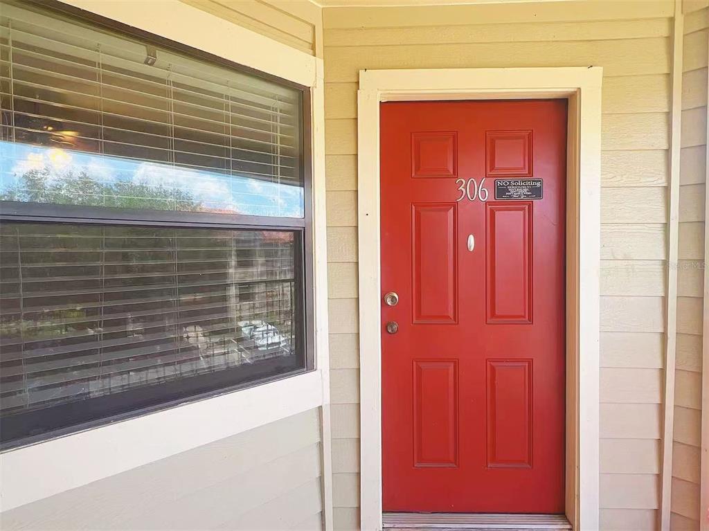 A red front door with the number 306 and a window with blinds — 3008 PARKWAY BOULEVARD UNIT 306, KISSIMMEE, FL