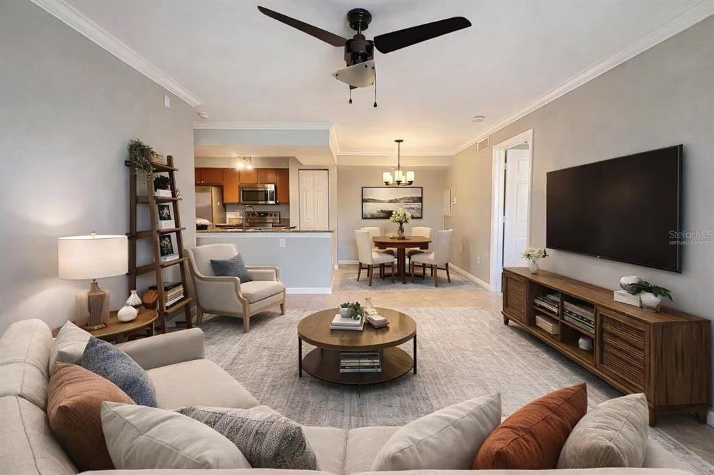 A living room with a ceiling fan, sectional sofa, television, and an adjacent dining area — 3008 PARKWAY BOULEVARD UNIT 306, KISSIMMEE, FL