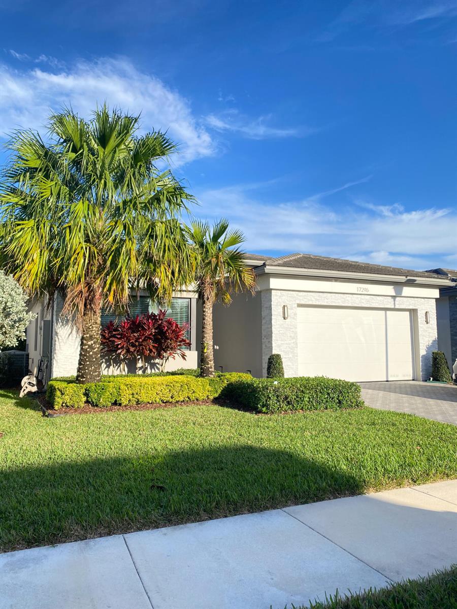 A single-story house with a white garage, stone accents, and palm trees in the front yard — 17296 Sea Blossom Way, Boca Raton FL 33496, BOCA RATON, FL