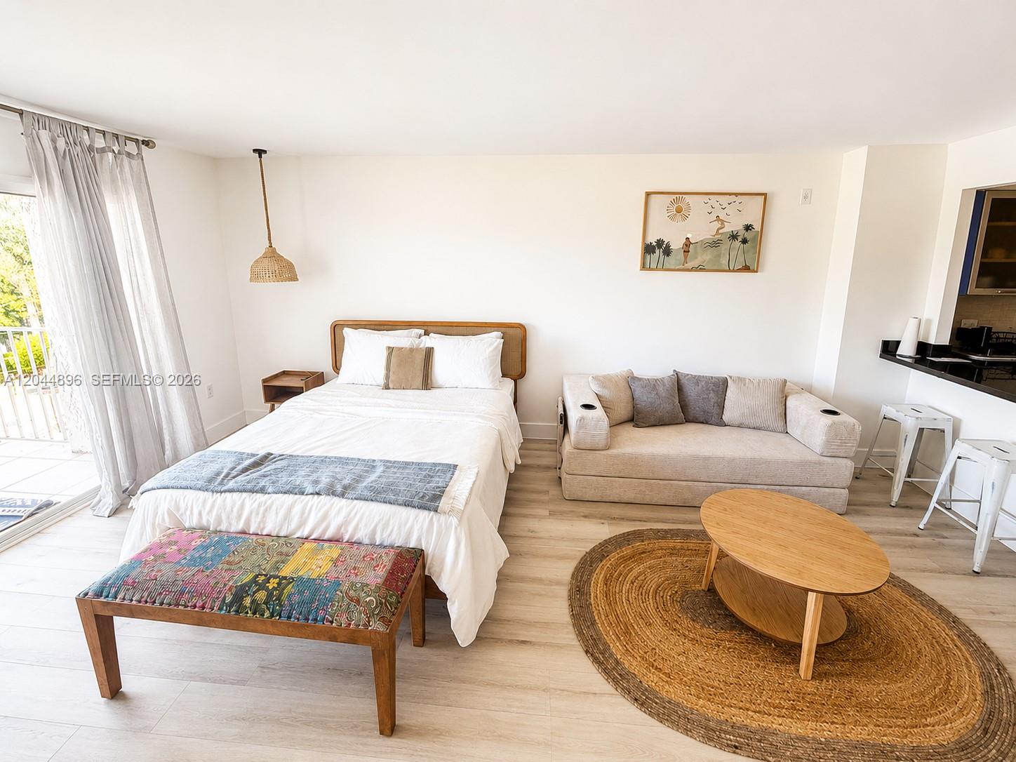 A studio apartment features a bed, a sofa, a coffee table, and a small kitchen — 650 NE 64 ST # G506, Miami FL 33138, MIAMI, FL