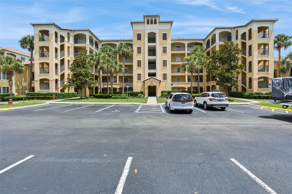 A multi-story apartment building with a parking lot in the foreground — 8774 WORLDQUEST BOULEVARD UNIT 7204, ORLANDO, FL
