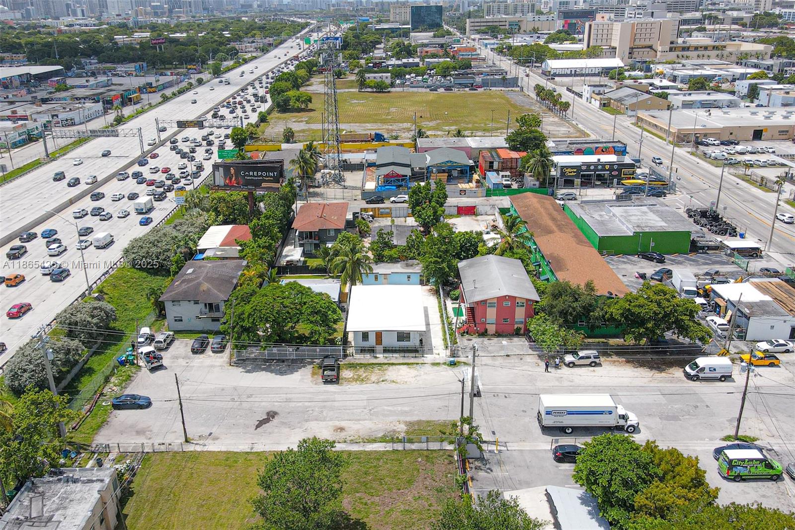 An aerial view shows several low-rise buildings and parking lots adjacent to a busy highway — 666 NW 28th St, Miami FL 33127, MIAMI, FL