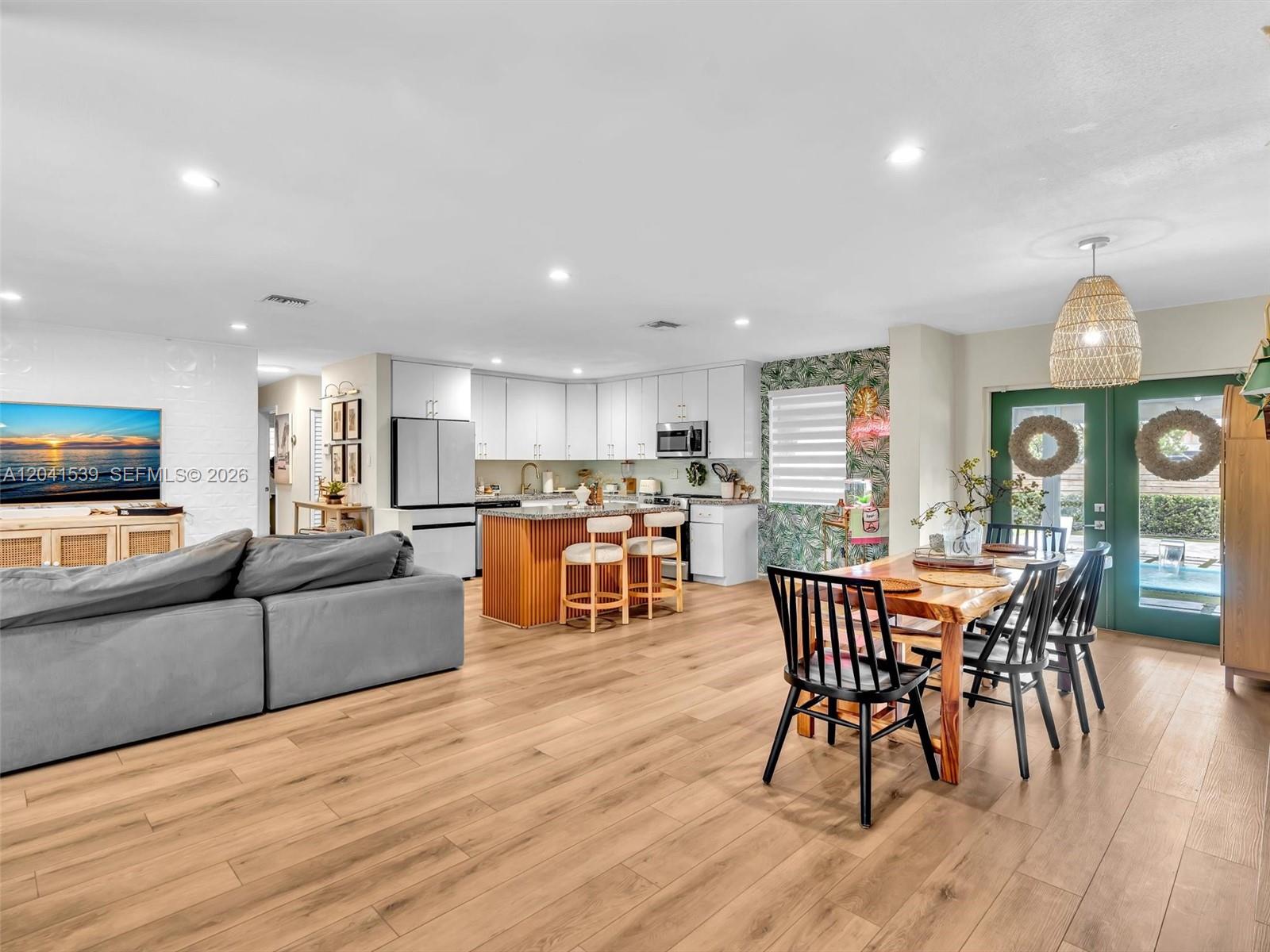 An open-concept living area features a kitchen with a wooden island, dining space, and flooring — 20210 SW 106th Ct, Cutler Bay FL 33189, CUTLER BAY, FL