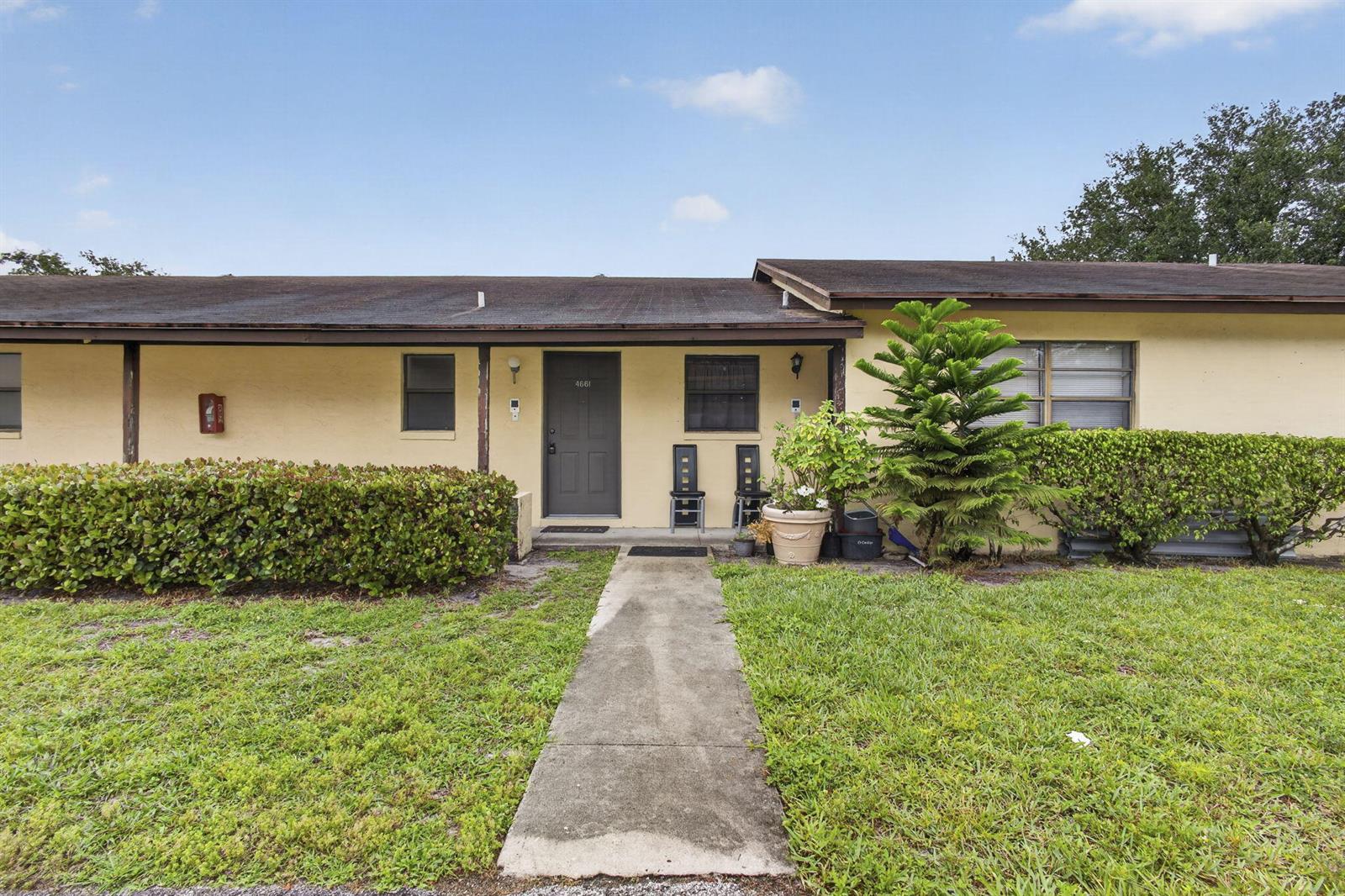 A single-story, yellow-stucco residential unit with a concrete walkway and a small front yard — 4661 Perth Road # 4661, West Palm Beach FL 33415, WEST PALM BEACH, FL