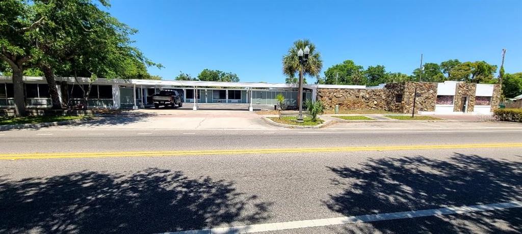 A single-story motel building with a stone facade and a covered parking area — 421 E KENNEDY BOULEVARD, EATONVILLE, FL