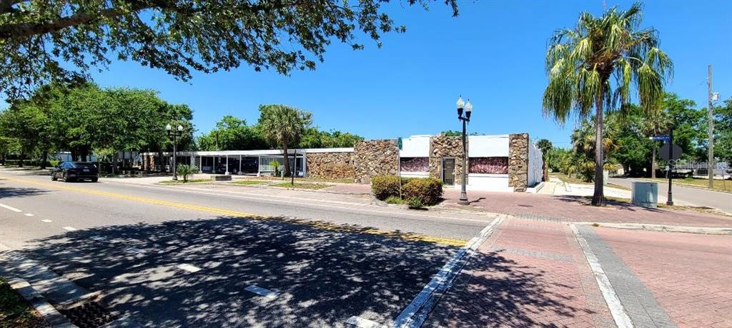 A low-rise commercial building with a stone facade sits along a street with palm trees — 421 E KENNEDY BOULEVARD, EATONVILLE, FL