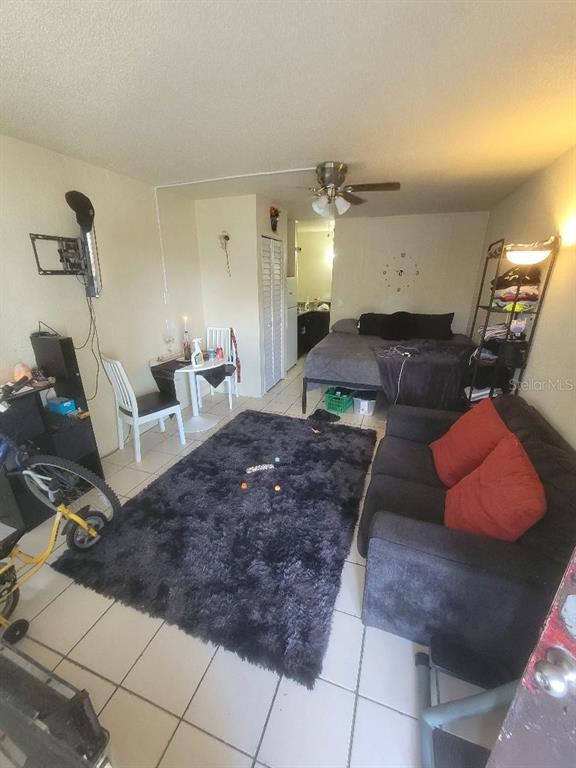 A studio apartment features a bed, a sofa with red pillows, and a dining table — 421 E KENNEDY BOULEVARD, EATONVILLE, FL