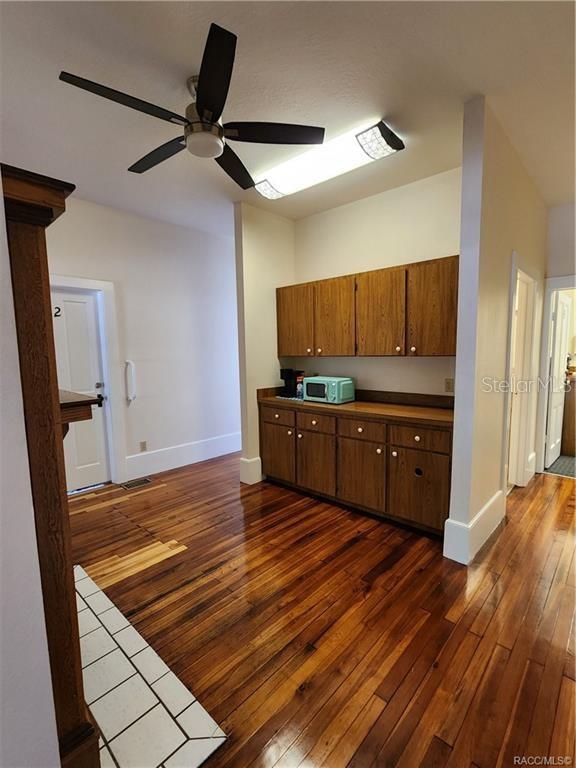 A room with hardwood floors, a ceiling fan, and wooden cabinetry along one wall — 101 S OSCEOLA AVENUE, INVERNESS, FL