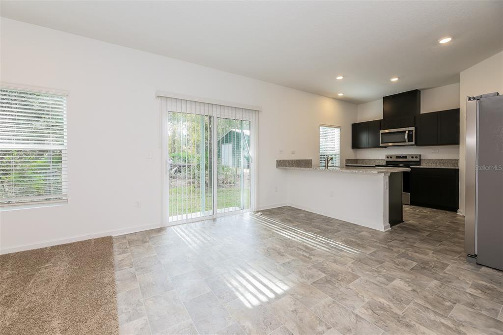 A kitchen with dark cabinets and a breakfast bar opens to a tiled dining area — 5008 BRAMANTE DRIVE, JACKSONVILLE, FL