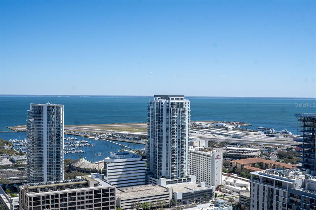 An elevated exterior view shows high-rise buildings, a marina, and an airport runway near water — 400 CENTRAL AVENUE UNIT 3606, ST PETERSBURG, FL