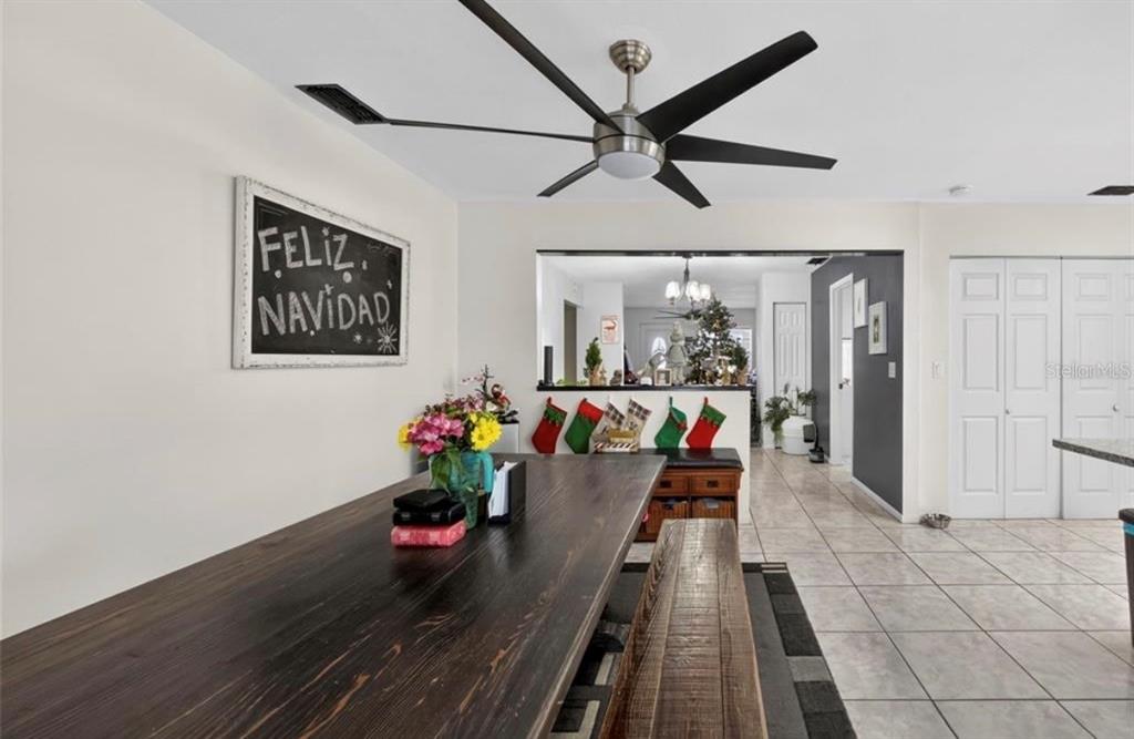 A dining room features a long wooden table, a ceiling fan, and Christmas decorations — 2914 W FRIERSON AVENUE UNIT C, TAMPA, FL