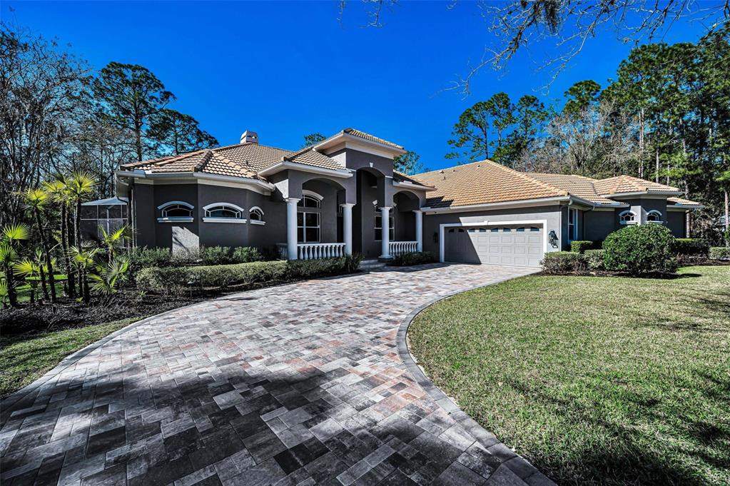 A single-story house with a tiled roof and arched windows sits on a grassy lot — 10709 WATULA COURT, NEW PORT RICHEY, FL
