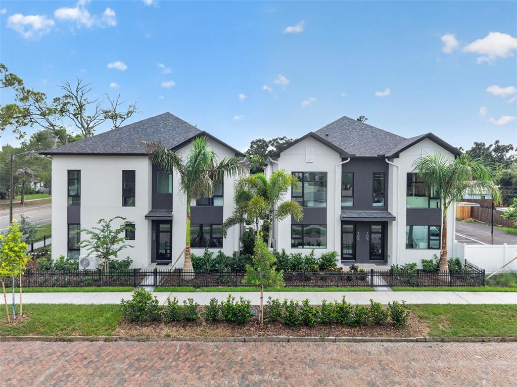 A modern two-story duplex building with white and dark gray exterior walls and palm trees — 100 36TH STREET N, ST PETERSBURG, FL