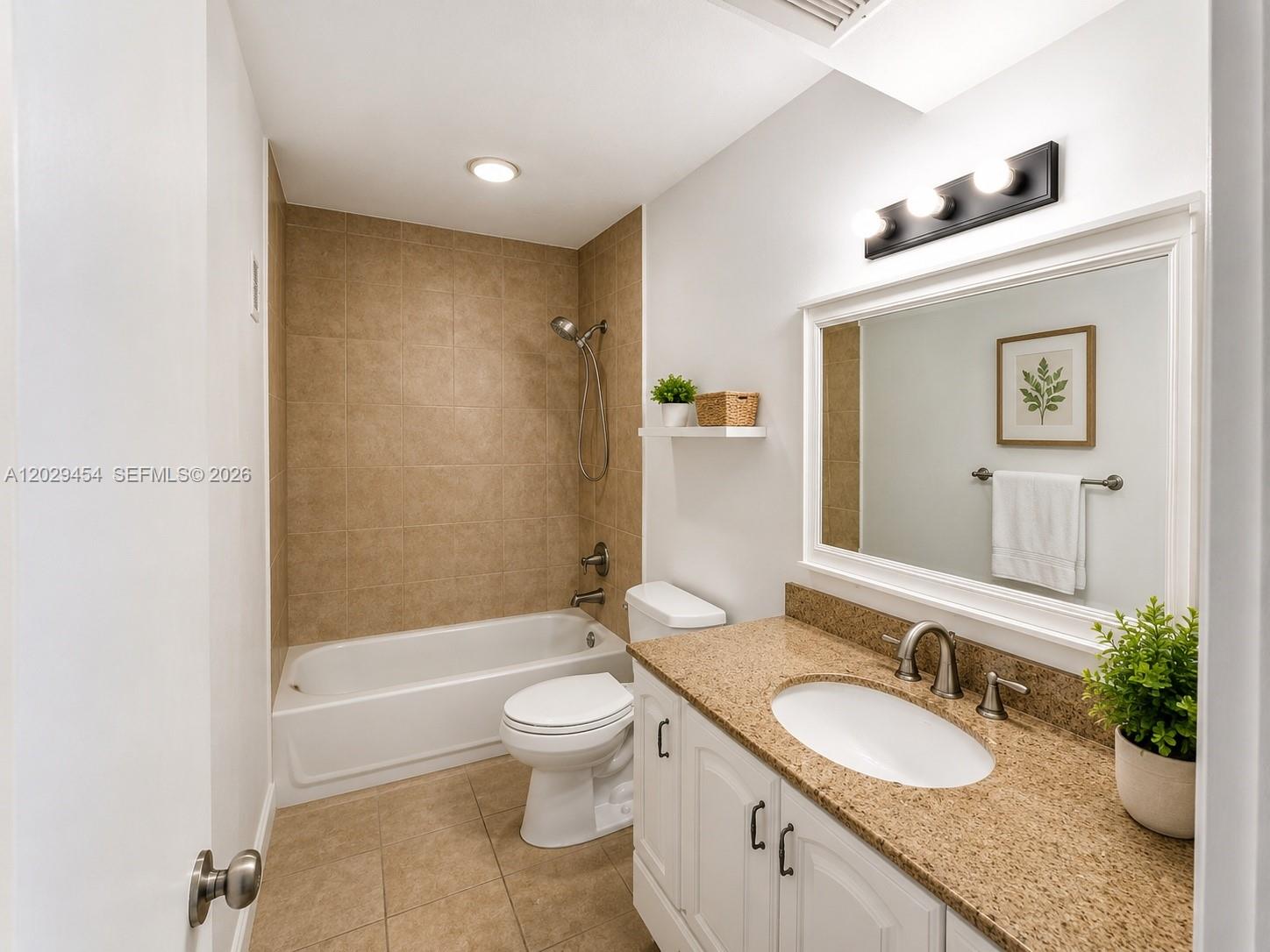A bathroom features a white vanity with a granite countertop, toilet, and tiled shower-tub combo — MIAMI, FL