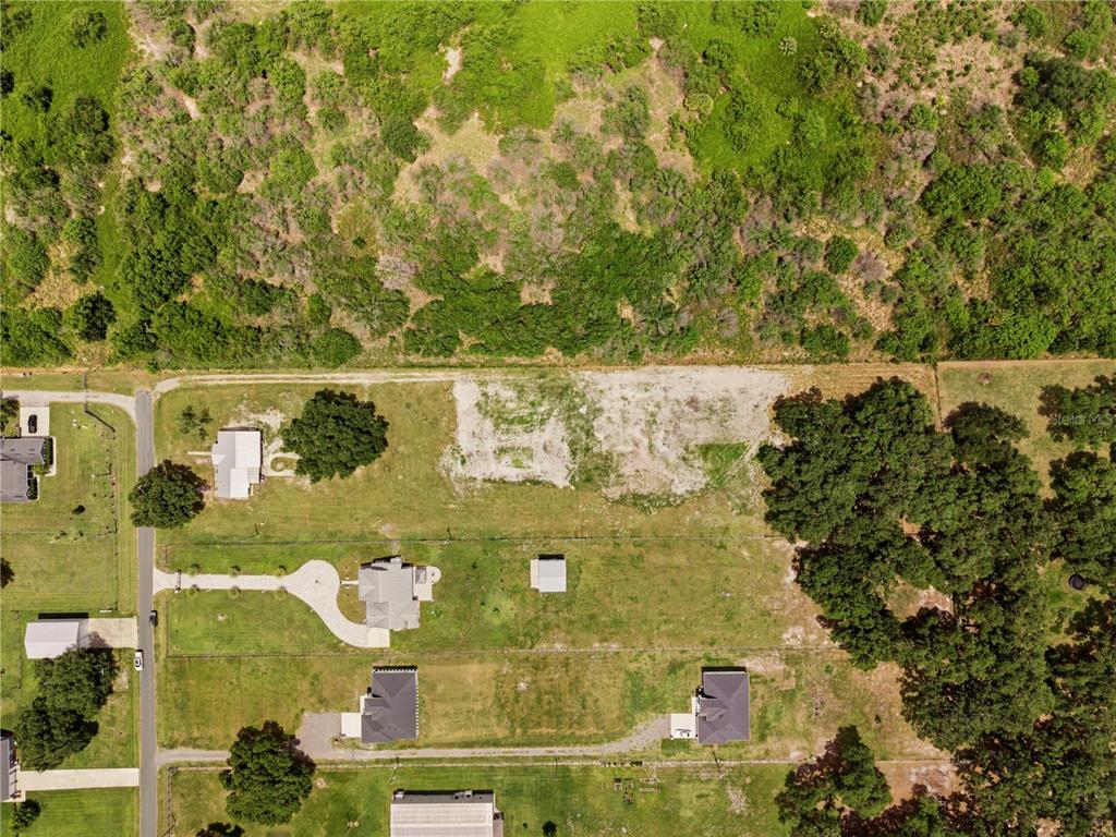 An aerial view shows a residential lot with a cleared building site and nearby houses — PARKWAY AVENUE, ST CLOUD, FL