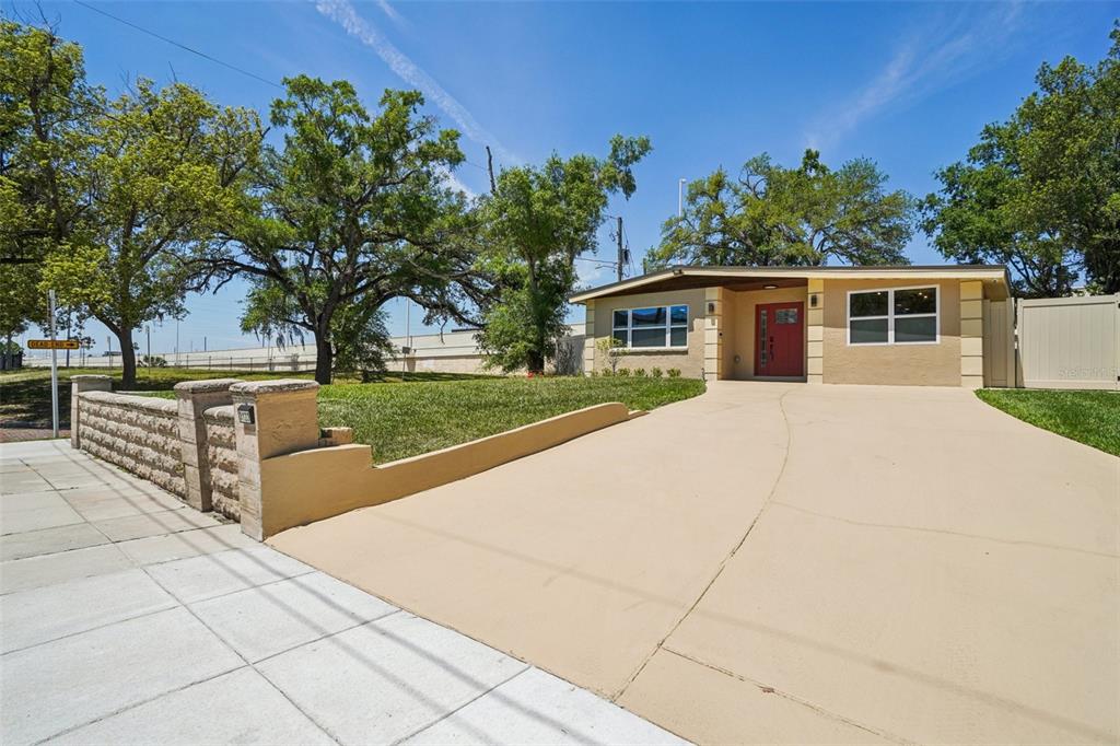 A single-story house with a red front door and a curved concrete driveway — 3123 W LA SALLE STREET, TAMPA, FL