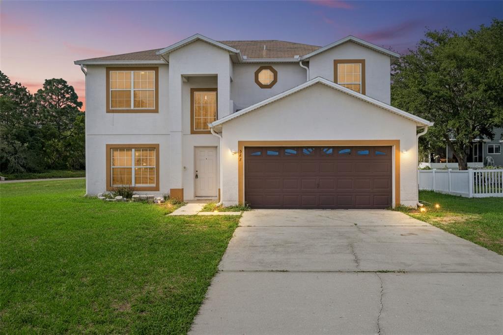 A two-story house with a white stucco exterior, brown trim, and an attached two-car garage — 342 PUFFER COURT, POINCIANA, FL