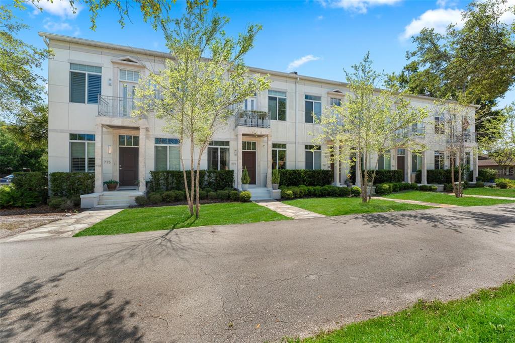 A row of multi-story townhouses with white facades, balconies, and small front lawns — 771 LAKE BALDWIN LANE, ORLANDO, FL
