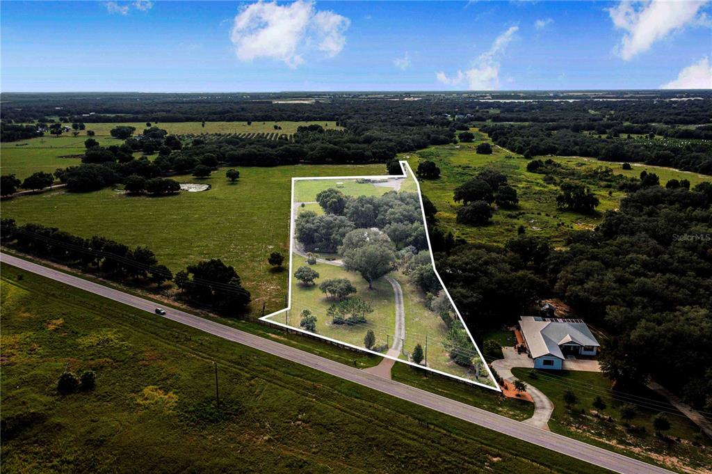 An aerial view shows a rural property with a house and trees outlined in white — 2424 BURNS AVENUE, LAKE WALES, FL