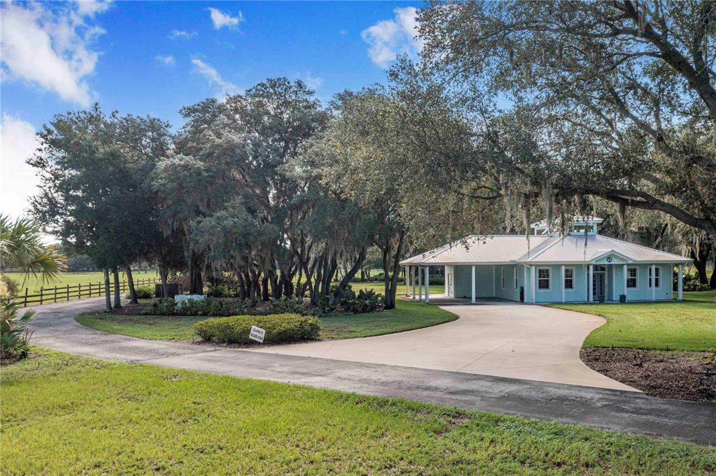 A light blue single-story house with a metal roof sits on a grassy lot — 2424 BURNS AVENUE, LAKE WALES, FL