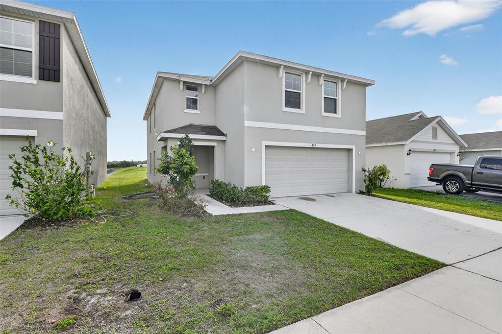 A two-story gray house with a two-car garage and a concrete driveway — 439 SUNLIT CORAL STREET, RUSKIN, FL