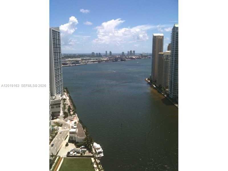 An elevated view of a waterway flanked by tall residential buildings under a blue sky — 200 Biscayne Boulevard Way # 4904, Miami FL 33131, MIAMI, FL